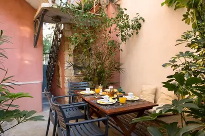 a wooden table with cups and saucers on a patio at Acropolis Neoclassical Mansion by YHA in Athens