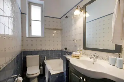a bathroom with a toilet and a sink and a mirror at Acropolis Neoclassical Mansion by YHA in Athens