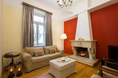 a living room with a couch and a fireplace at Acropolis Neoclassical Mansion by YHA in Athens