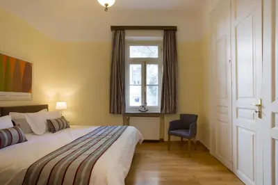 a bedroom with a bed and a window and a chair at Acropolis Neoclassical Mansion by YHA in Athens