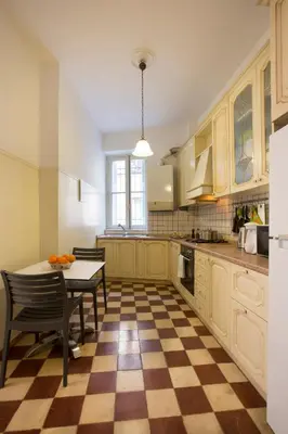 a kitchen with a table and a checkered floor at Acropolis Neoclassical Mansion by YHA in Athens