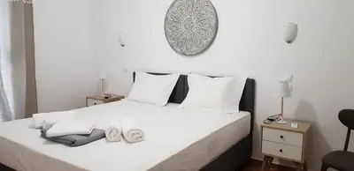 a bedroom with a white bed with towels on it at Apartment at Acropolis Museum by YHA in Athens