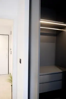 a walk in closet with white walls and a mirror at Seafront Apartment by C2C Architects in Kalívia Thorikoú