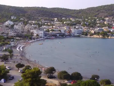 a beach with a bunch of people in the water at Villa Alexandra in Agia Marina Aegina