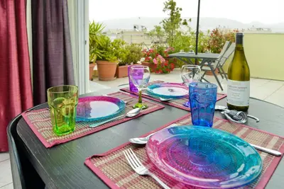 a table with plates and glasses and a bottle of wine at Kalypso Apartment in Athens