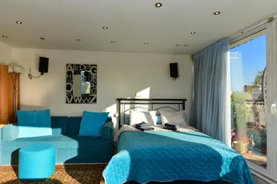 a bedroom with a blue bed and a couch at Kalypso Apartment in Athens