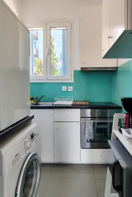 a kitchen with white cabinets and a washing machine at KYMA Apartments - Athens Acropolis 7 in Athens