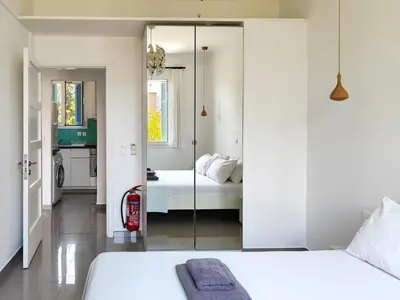 a bedroom with a glass door leading to a bathroom at KYMA Apartments - Athens Acropolis 7 in Athens