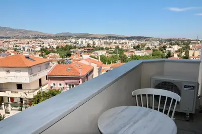 a balcony with a table and a chair and a city at Villa Ariadne in Athens