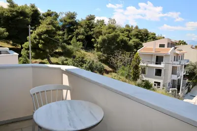 a chair on a balcony with a view of a building at Villa Ariadne in Athens