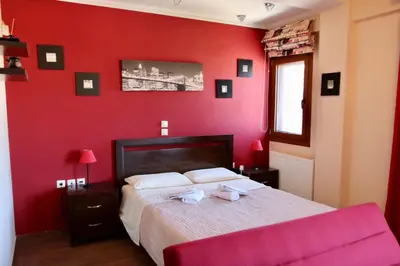a red bedroom with a bed and a red wall at Villa Ariadne in Athens