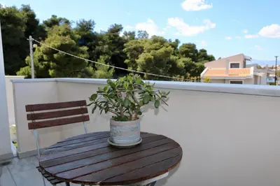 a wooden table with a potted plant on a balcony at Villa Ariadne in Athens