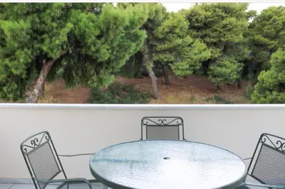 a glass table and chairs in front of a window at Villa Ariadne in Athens