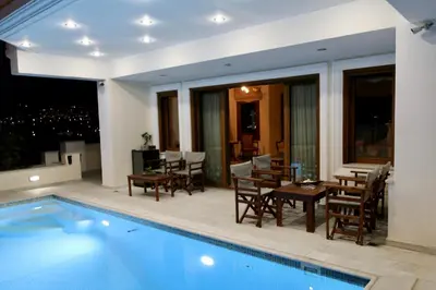 a house with a swimming pool and a dining area at Villa Ariadne in Athens