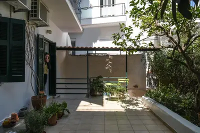 an internal courtyard of a house with a woman standing in the doorway at Miranda's Apartment in Thissio in Athens