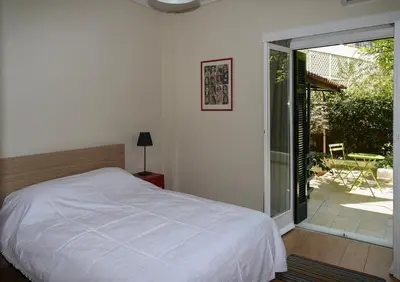 a bedroom with a bed and a sliding glass door at Miranda's Apartment in Thissio in Athens