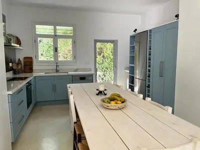 a kitchen with a wooden table with a bowl of fruit at Saronida Boutique Villa Private Pool, Sea views, Lovely Gardens & Roof Terrace in Saronida