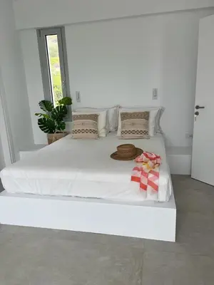 a white bed with a hat and towels on it at Saronida Boutique Villa Private Pool, Sea views, Lovely Gardens & Roof Terrace in Saronida