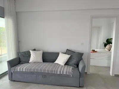 a gray couch in a living room with a mirror at Saronida Boutique Villa Private Pool, Sea views, Lovely Gardens & Roof Terrace in Saronida