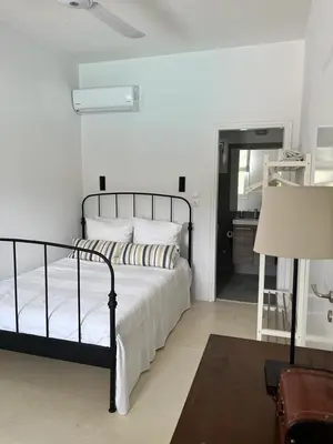 a bedroom with a bed with white sheets and a lamp at Saronida Boutique Villa Private Pool, Sea views, Lovely Gardens & Roof Terrace in Saronida