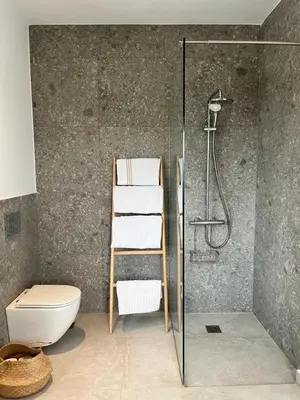 a bathroom with a shower and a toilet and towels at Saronida Boutique Villa Private Pool, Sea views, Lovely Gardens & Roof Terrace in Saronida