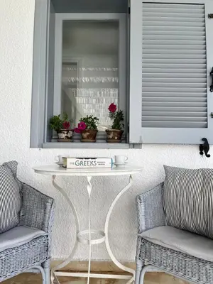a table in a room with two chairs and a window at Saronida Boutique Villa Private Pool, Sea views, Lovely Gardens & Roof Terrace in Saronida