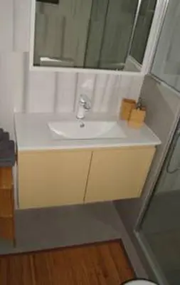 a bathroom with a white sink and a mirror at Illisia Roof Apartment in Athens