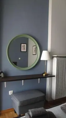 a blue room with a mirror and a stool and a lamp at Illisia Roof Apartment in Athens