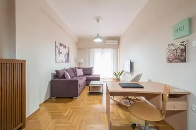 a living room with a couch and a table at Sofihome Ampelokipi Station in Athens