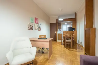 a living room with a white chair and a desk at Sofihome Ampelokipi Station in Athens