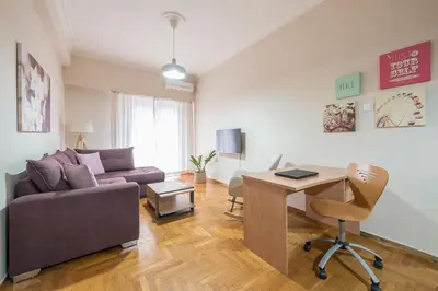 a living room with a couch and a desk at Sofihome Ampelokipi Station in Athens