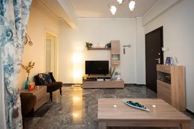 a living room with a couch and a tv at Blue Ark Athenian Nest in Athens
