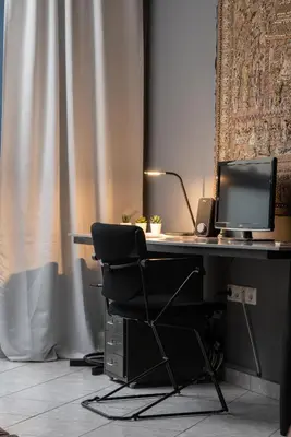 a desk with a computer monitor and a chair at Comfort Stay Lofts in Athens
