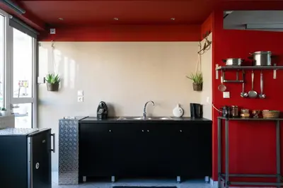 a kitchen with a sink and a red wall at Comfort Stay Lofts in Athens