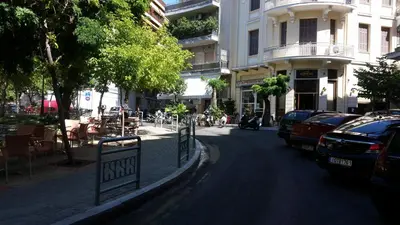 a street with cars parked on the side of the road at Errathens Wheat Apartment - Athens Center, 3 BD, 1 BATH in Athens