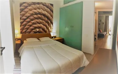 a bedroom with a large white bed with a painting on the wall at Flat31 in Athens