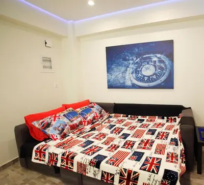 a bed with a quilt and pillows in a room at George Studio in Athens