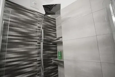 a shower with a glass door in a bathroom at George Studio in Athens