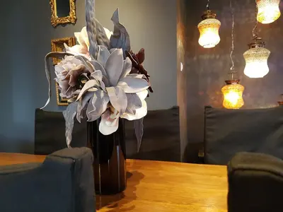a vase filled with flowers sitting on a table at ADMETUS PSYRRI LOFT by K&K in Athens