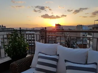 a balcony with a couch and a sunset on a ship at ADMETUS PSYRRI LOFT by K&K in Athens