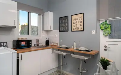 a kitchen with white cabinets and a wooden counter top at Acropolis Apartment with a unique view in Athens