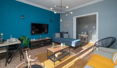 a living room with a blue wall at Acropolis Apartment with a unique view in Athens
