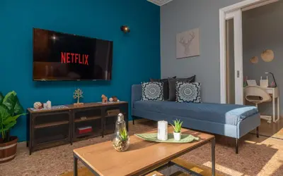 a living room with a couch and a tv on a wall at Acropolis Apartment with a unique view in Athens