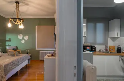 a kitchen and a living room with a bed in a room at Acropolis Apartment with a unique view in Athens