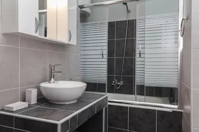 a bathroom with a sink and a glass shower at Acropolis Apartment with a unique view in Athens