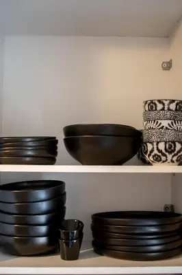 a group of black bowls and plates on a shelf at Apartment Vresthenis in Athens