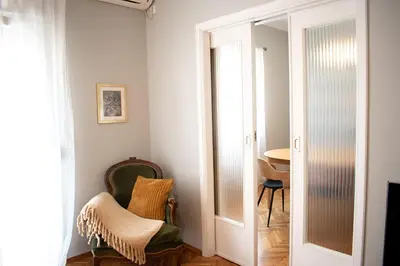 a room with a door and a chair and a table at Apartment Vresthenis in Athens