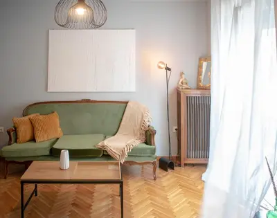 a living room with a green couch and a table at Apartment Vresthenis in Athens