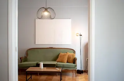 a living room with a green couch and a table at Apartment Vresthenis in Athens