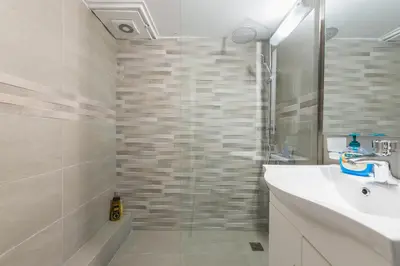 a bathroom with a sink and a shower at Stylish Athens Apt 10 Minute Walk to Acropolis Museum & Metro in Athens
